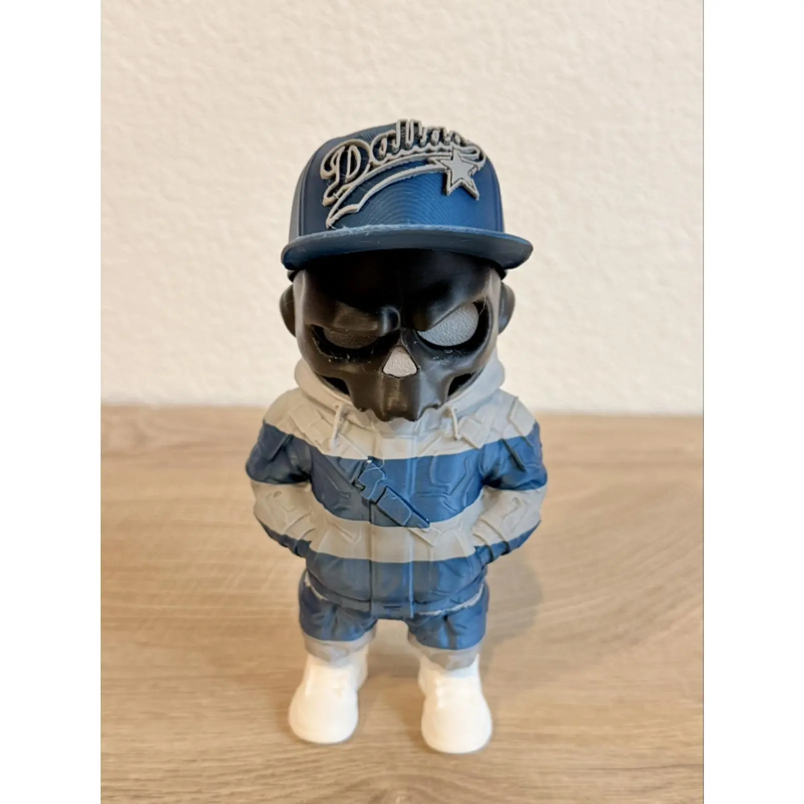 Dallas-themed Skull Figure in Blue and White Striped Outfit with Cap