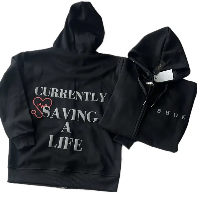 Singular Shok “Currently Saving A Life” Zip Up Black Hoodie. Oversized or Fitted Pure Cotton Style. For EVERYBODY not just Healthcare Professionals!