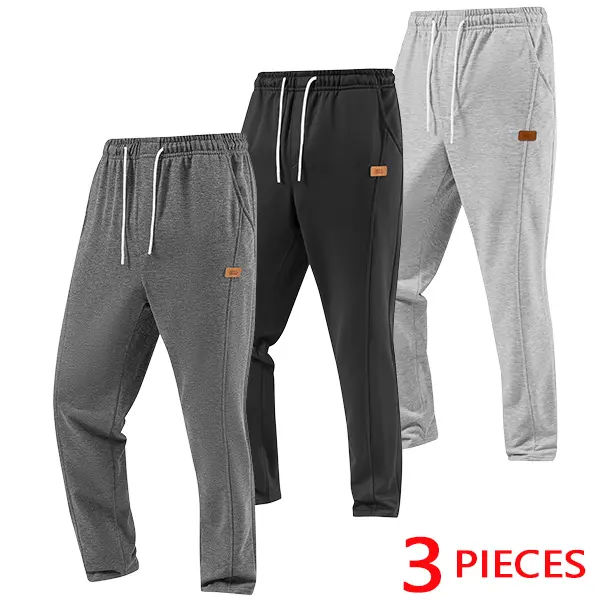 Men’s casual sweatpants with small leather tag detailing; sporty loose-fit pants with a drawstring waist—ideal for autumn and winter. Fashionable men’s straight-leg, loose-fit long pants for everyday walks and casual wear.