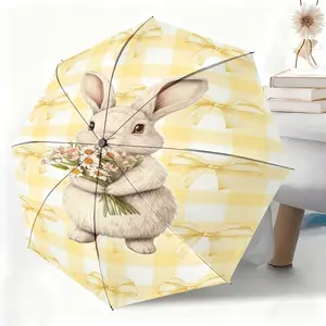This waterproof folding umbrella features a yellow and white checkered background with a rabbit holding flowers design. Suitable for both men and women, it's portable and ideal for travel and everyday use.
