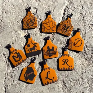 Custom leather cattle ear tag keychains .