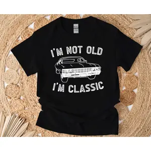 Women's automotive nostalgia and humor Graphic T-Shirt - Short Sleeve Crew Neck Regular Fit Casual Wear | Soft & Breathable Fabric, Durable Print, Everyday Comfort, Machine Washable, casual and humorous flat lay product photography with natural textured