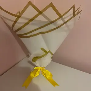 Elegant White and Gold Floral Wrap with Yellow Ribbon for Gift Presentation - Perfect for Snack and Flower Arrangements