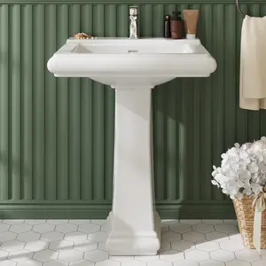 Save floor space with this modern white ceramic pedestal sink. The rectangular basin measures 26.4"W x 21.7"D x 34.1"H and includes a single faucet hole, overflow, and integrated backsplash. Link in bio.