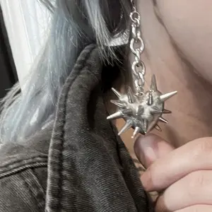 A two-piece set of punk-style heart-shaped spike earrings, featuring fashionable silver chain pendants. Suitable for both men and women, these Gothic-inspired earrings are perfect for everyday wear, parties, and music festivals.