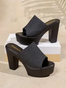 A pair of denim platform heel slide sandals with chunky block heel and open-toe design. The classic fabric and elevated sole add height and style, perfect for elevating streetwear and casual summer looks.