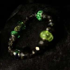 Nurobi by Pynk Peacock featuring glass beads and emerald glass donut beads. This bracelet is an extra small size 5