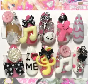 kawaii jpop inspired press on nails with 3d charms featuring music notes, bows, keys, roses, buttons, cute faces and playful pastel designs for a fun decora vibe