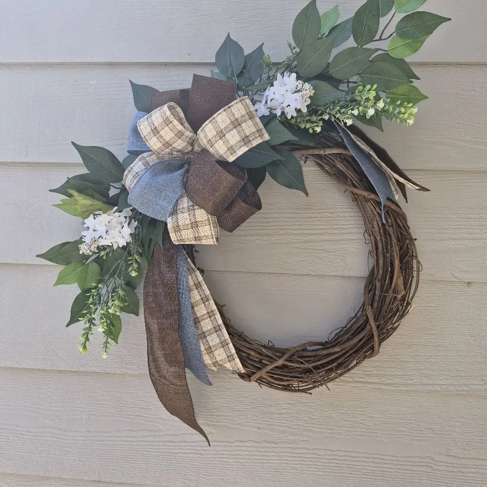 This 18 inch handmade grapevine wreath features a rustic, farmhouse aesthetic suitable for year-round or seasonal decor.