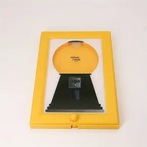 Wall-mounted square plastic picture frame with a candy, nut, or pet treat dispenser. Bright yellow-green color and no electricity required. Perfect for the kitchen, living room, child's room, or office, with its fun design and sturdy construction.