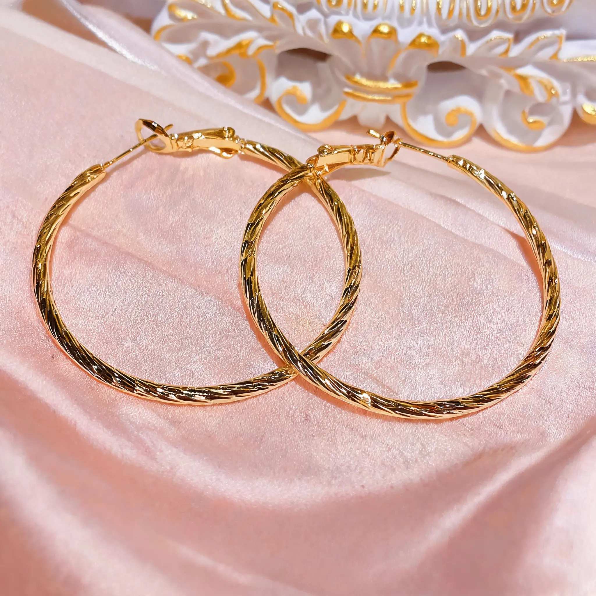Women's 14K gold plated twisted textured large hoop earrings. Lightweight, hypoallergenic, 40mm circle hoops with hinge click-top clasp. Elegant for daily wear, date nights, and gifting