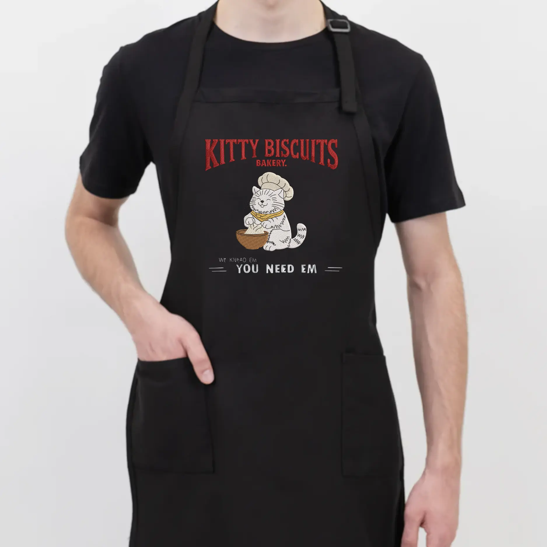 Kitty Biscuits Embroidered Apron - Black Apron with Kitty Biscuits Design and 'You Need Em' Text