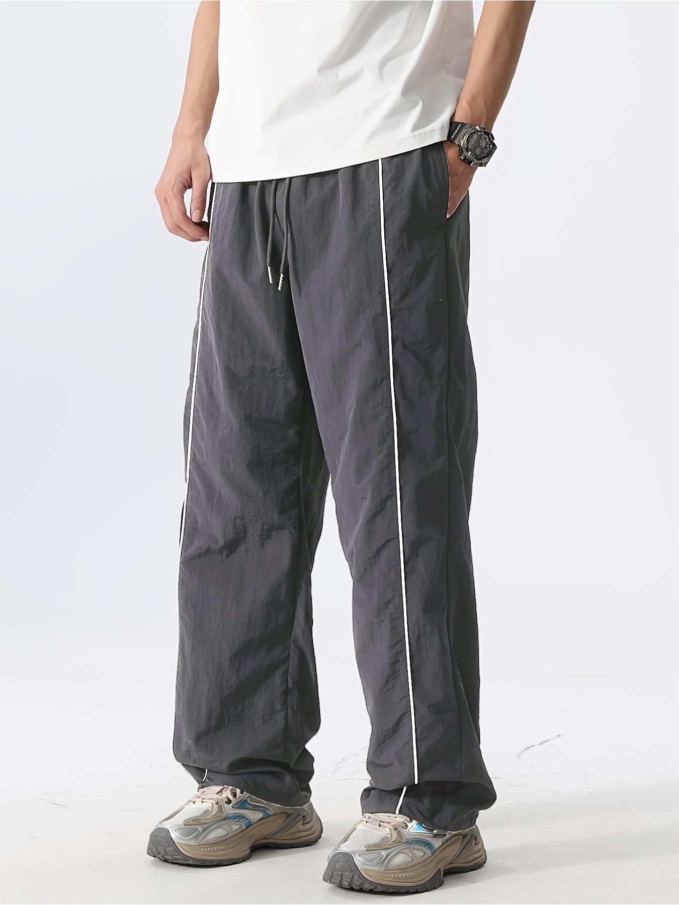 Men’s fashion loose fit long pants with side stripe paneling, drawstring waist, and elastic cuffs—perfect for everyday casual wear.