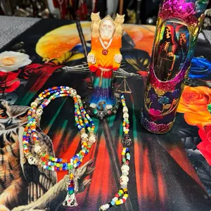 Santa Muerte Statue with Colorful Beaded Necklace and Vibrant Decorative Vase for Rituals and Altars