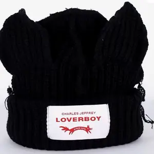 Charles Jeffrey Loverboy Black Knit Hat with Front Ear Pieces and White Tag Featuring Character Design