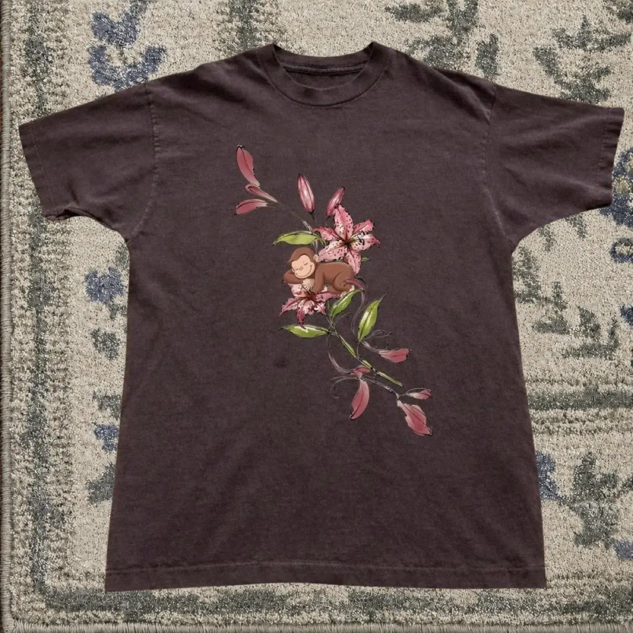 Brown monkey graphic tee with pink lily flowers and green leaves