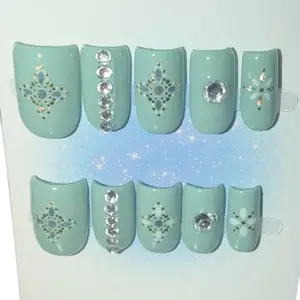 Elegant Mint Green Nail Art with Rhinestones and Floral Designs for a Chic Look