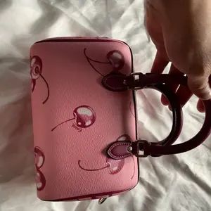 C Cherry Mini Rowan Bag - Pink Color, Leather Material, Compact Design, Features Decorative Spots, Durable Closure