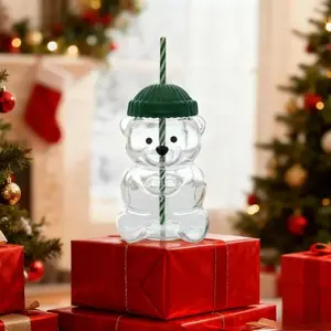 The Beary Cute Coffee and Cold Drink Cup features a teddy bear-shaped body and a striped straw. This 17-ounce high-quality glass mug is suitable for coffee, beer, wine, cocktails, and other beverages, and comes with a green knitted hat-style lid.