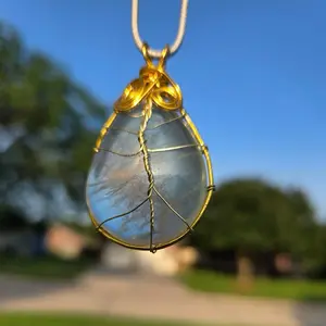 Fluorite Necklace - Gold-Tone Wire Wrapped Tear Drop Pendant Against Blue Sky Background