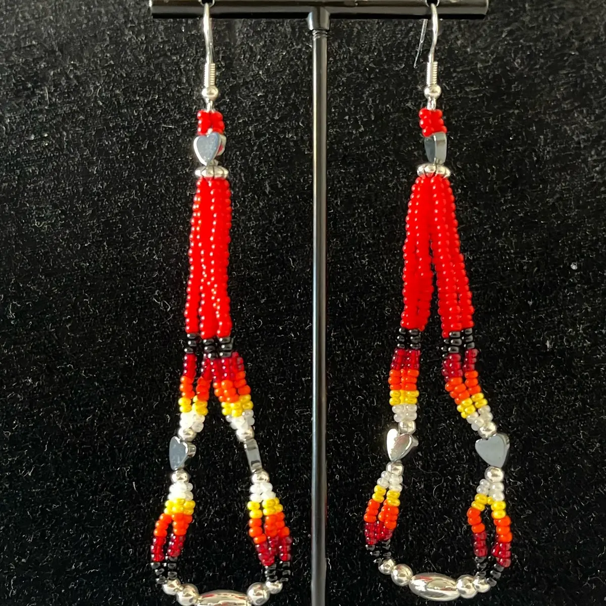 Navajo handmade beaded earrings adorned with red warrior seed beads, fire design seed beads, heart-shaped hematite beads, and silver alloy daisy beads.