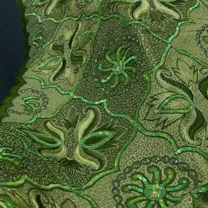 Luxury embroidered fabric featuring an intricate floral and geometric pattern worked in emerald and sage green tones.