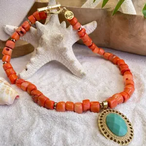 Collar de coral con dije de cristal turquesa y piedras volcánicas.
