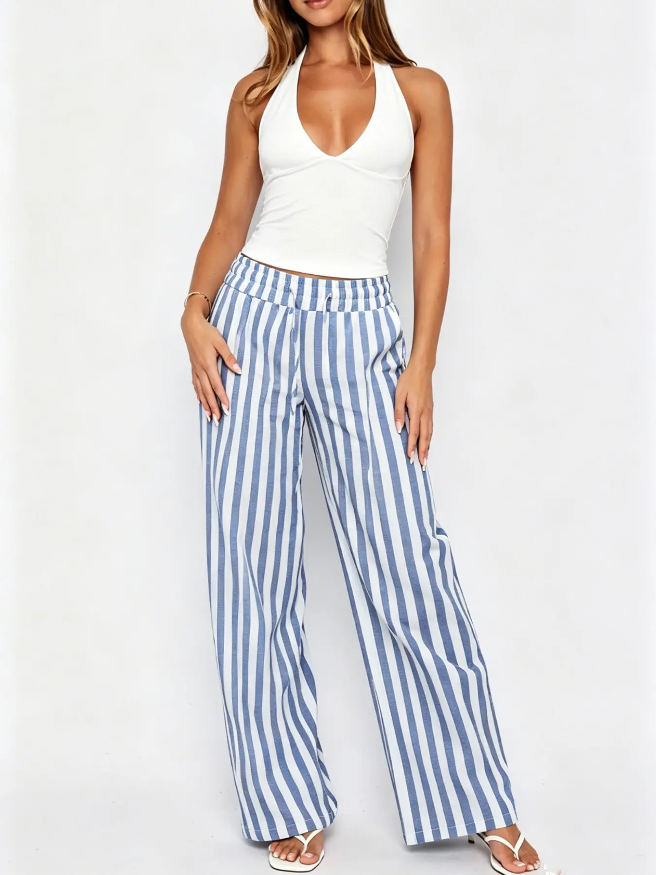 Two-piece set: Women's white halter top paired with blue striped wide-leg trousers. A casual, vacation-ready street style perfect for the summer beach. #Vacation+Preppy+Casual Beachwear