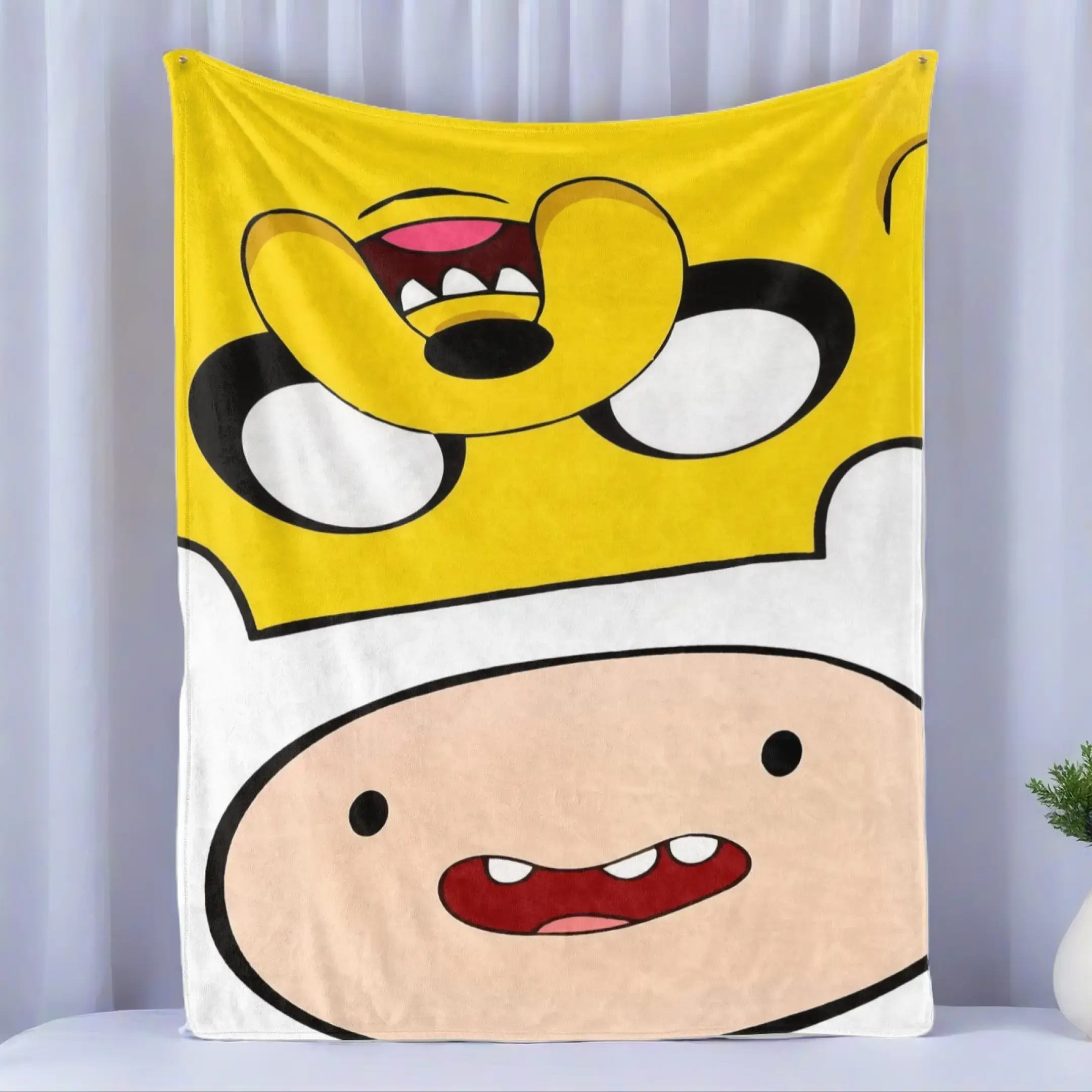 Adventure Time Finn & Jake Close-Up Flannel Fleece Blanket – Bold yellow and white split backdrop with playful, oversized faces of Finn and Jake, capturing the silly charm of the animated series, perfect for cozy cartoon marathons and fans