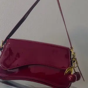 Elegant Red Patent Leather Crossbody Bag with Gold Cherry Charm and Adjustable Strap