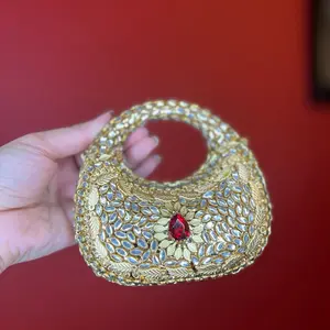 Noor Luxe Statement Clutch with Intricate Gold Embellishments and Red Gemstone Centerpiece