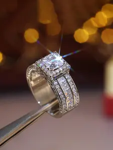 The main diamond is cut in a square shape, surrounded by a circle of broken diamonds to form a gorgeous border. The overall shape is grand and layered, giving people a luxurious and noble feeling Band Ring Diamond Halo Ring