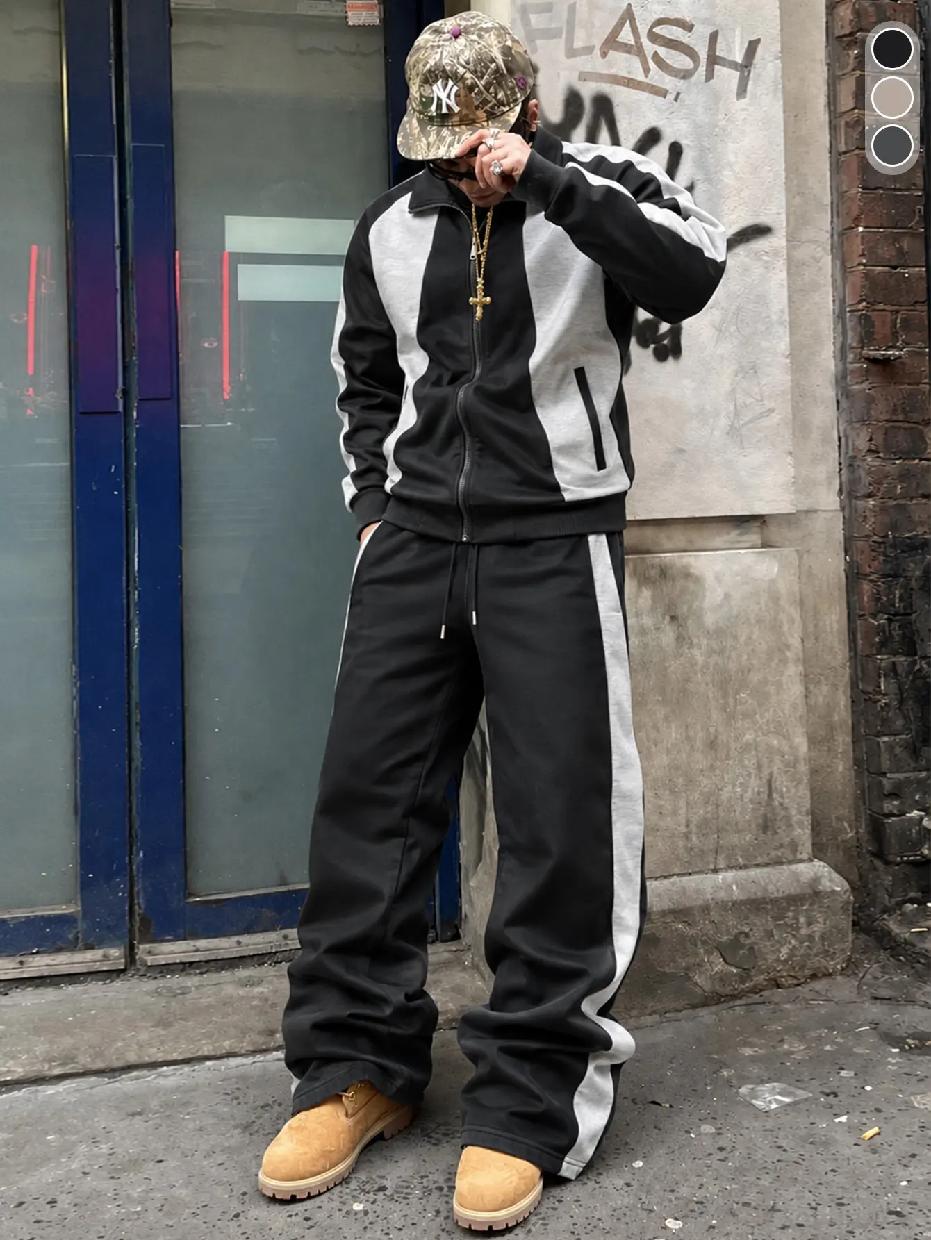 Men’s black-and-gray color-blocked athletic set featuring a stand collar jacket with vertical stripe panels and full-zip closure, paired with wide-leg pants with white side stripes; relaxed drop-shoulder fit, American retro street style for everyday commu