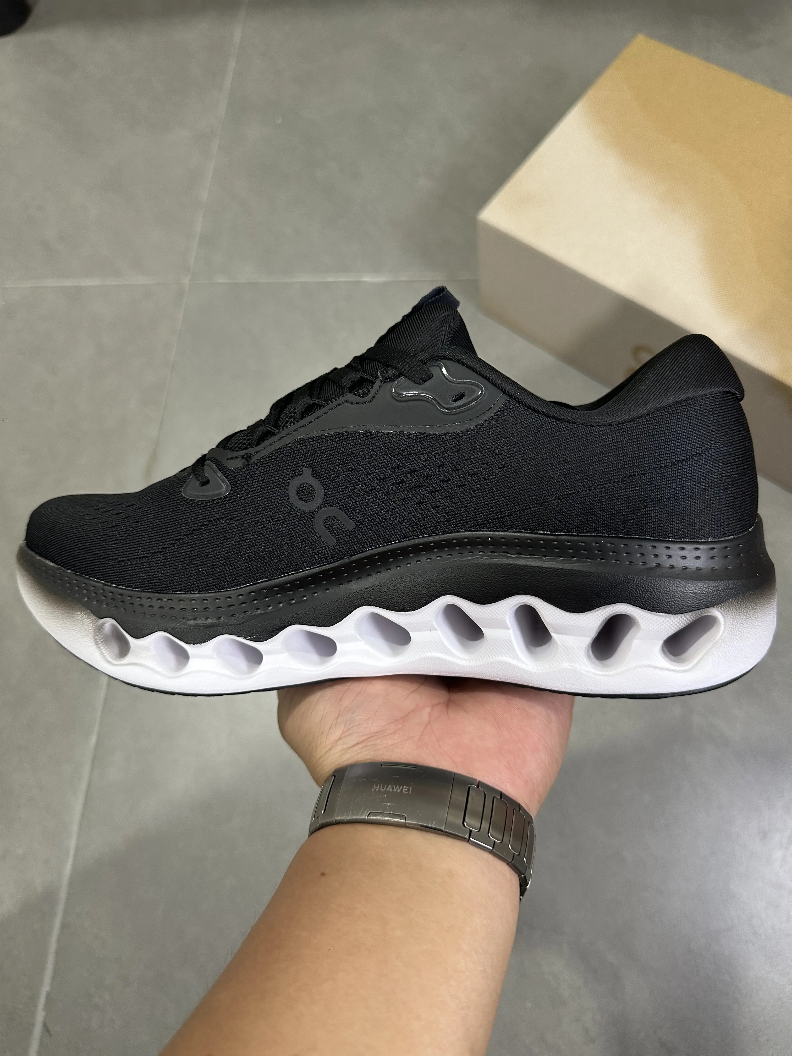 Black white contrast monochrome cushioned low-top running sneakers featuring scuff-proof white hollow wave layered rubber outsoles, tear-resistant sweat-wicking stretch knit mesh construction, mesh embedded perforated cutouts