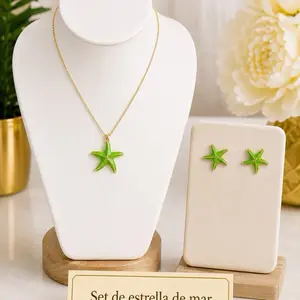 Hermoso set inspirado en el mar. Incluye una delicada cadena con dije de estrella de mar y aretes a juego en un hermoso tono verde con detalles dorados. Oro laminado 14k