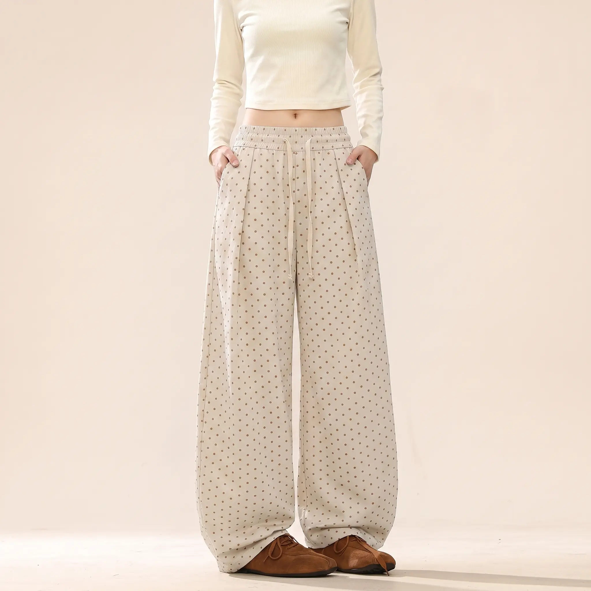 Pink polka dot wide-leg casual pants for young women with a fluid drape; high-waisted elastic drawstring pleated straight-leg design; retro small polka dot print detailing; loose fit that flatters and elongates; Korean-style soft girl aesthetic; suitable