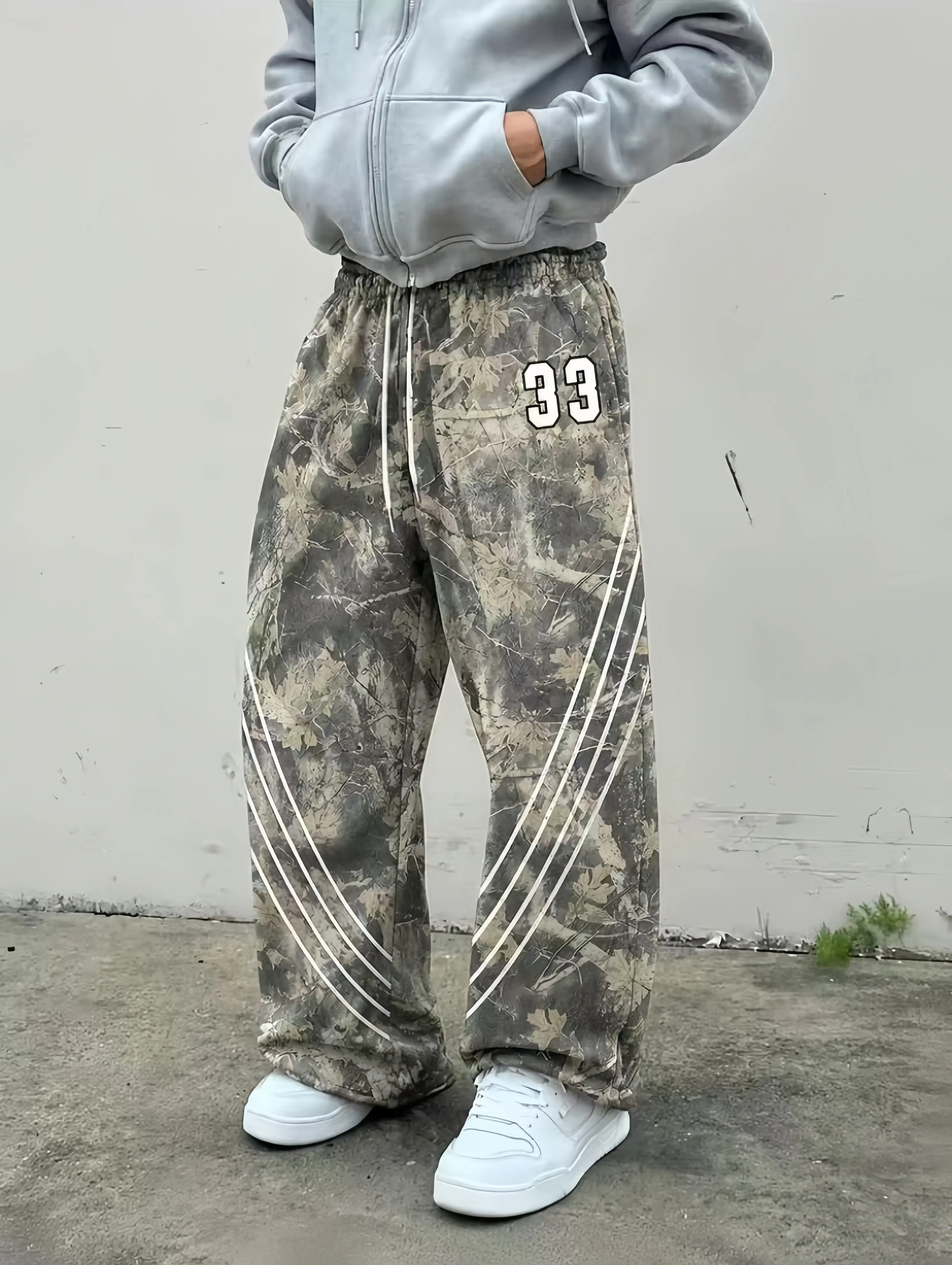 Men’s high-street jungle leaf camouflage wide-leg sweatpants, size 33 patch, side slanted three-stripe design, elastic drawstring waist, drapey floor-length casual athletic pants, vintage forest distressed camouflage straight-leg street trend sports pants