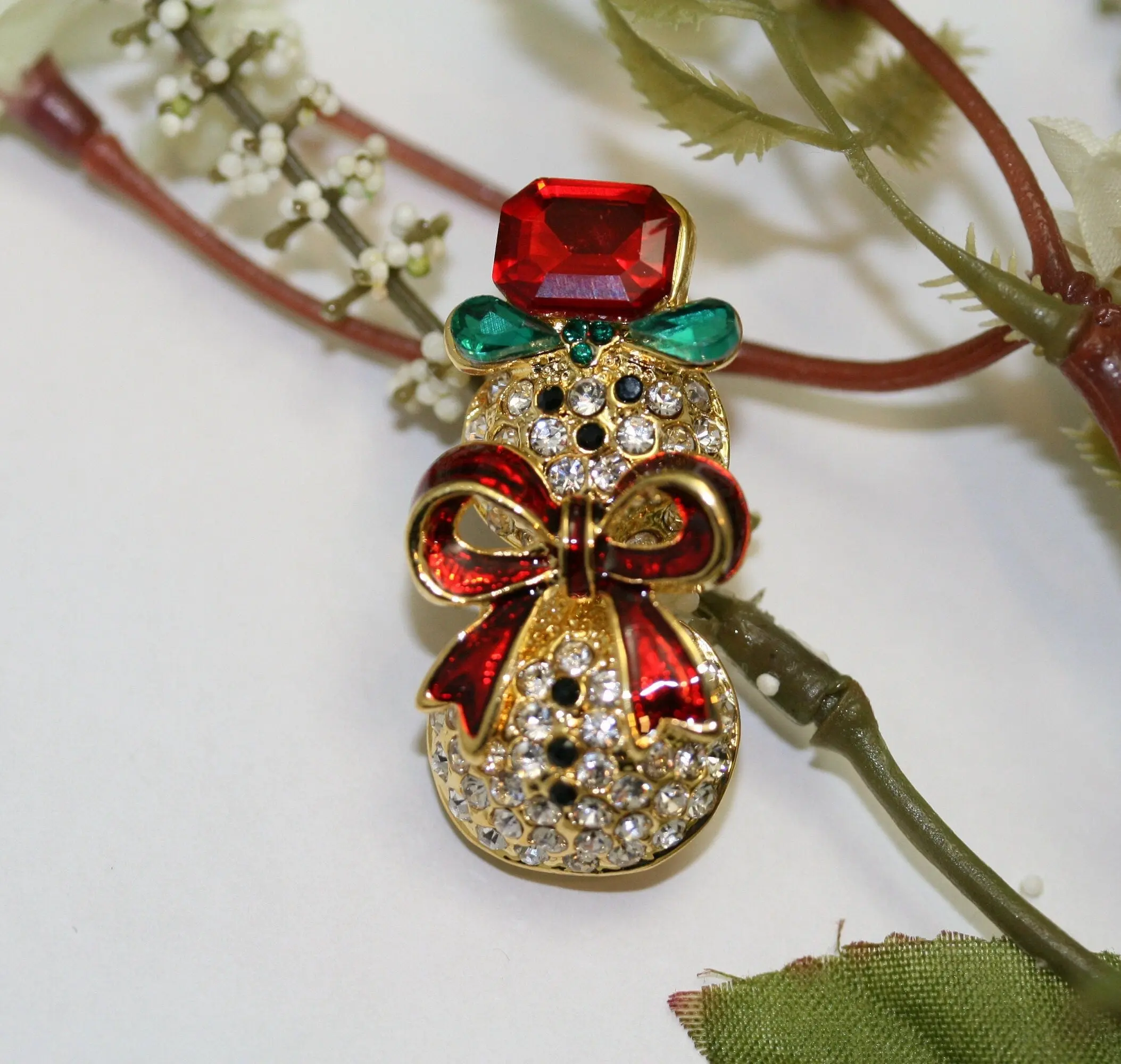 Christmas Snowman Brooch with Red Enamel Bow, Ruby Rhinestone and Green Teardrop Gems, Unisex Holiday Pin, 1.5x0.75 in, 1.5"H X 0.75"W, 2 Teardrop Green Stones