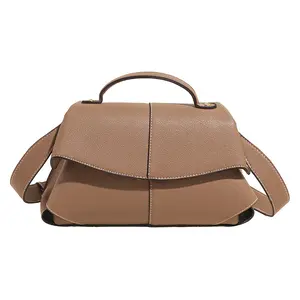 A minimalist, versatile luxury tote bag with a pebbled texture, suitable for both shoulder and crossbody wear.