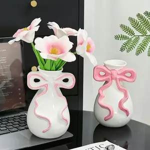 An imaginative bow-shaped resin vase - romantic wedding and home decor item, featuring elegant pink and white flower designs. It is the ideal gift for brides, girlfriends, birthdays or graduation ceremonies.