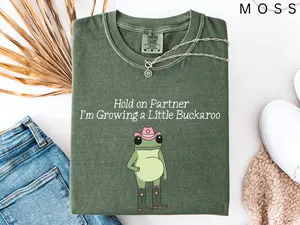 Comfort Colors Hold On Partner I’m Growing A Little Buckaroo TShirt, Funny Western Baby Reveal Gift, Western Frog Shirt, Pregnancy Reveal Shirt, First Time Mom Gift