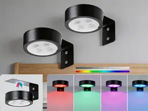 4-pack battery-operated picture lights with remote control. Dimmable LED lights equipped with timer function, designed for artwork, paintings and portrait frame display. Black puck-style fixtures for home wall decorative lighting.