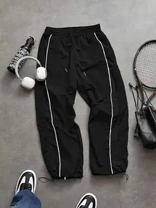 Men’s parachute pants with white side stripes, elastic drawstring waist, adjustable ankle cuffs, lightweight nylon joggers for streetwear, gym, and casual everyday wear
