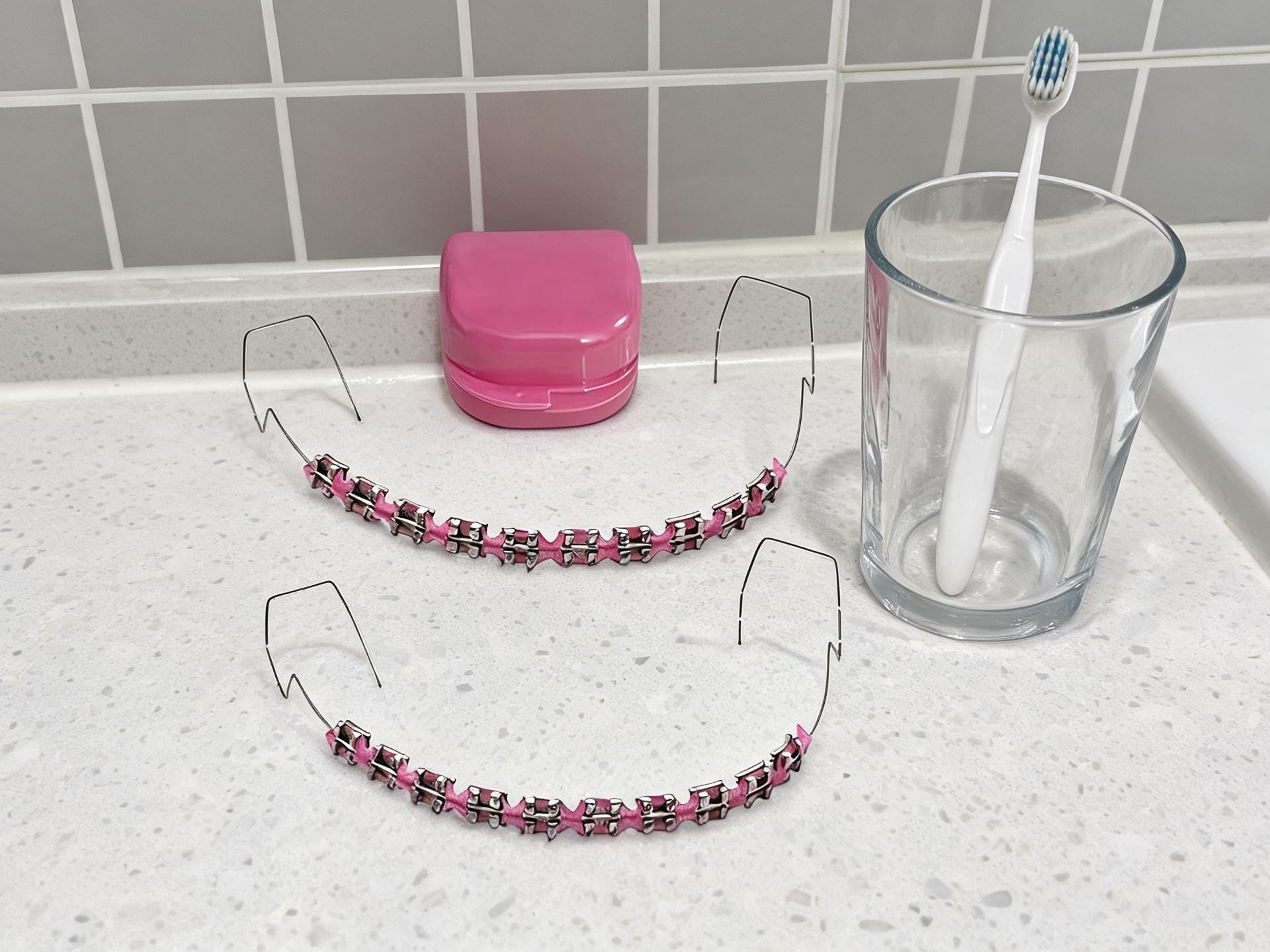 Colorful Metal Dental Braces Set,2-Piece Temporary Fake Braces Set, featuring metal wires, brackets and orthodontic bands in pink. Designed for dental student practice and orthodontic demonstration use.