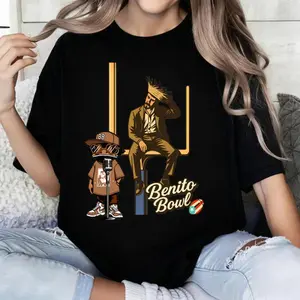 A black T-shirt featuring a super mid-cheek-shaped football and cartoon character patterns, with an atmosphere of championship contenders. It is a must-have item for game day gatherings. # Game Day Style. # TK100CottonTshirt # Fan Apparel