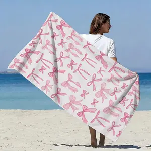 Pink bow-adorned beach towel made of microfiber. Quick-drying and highly absorbent, it’s perfect for beach vacations, pool parties, and relaxing on the sand.