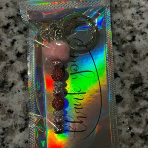 The Pink Pom Keychain with Holographic Packaging and Beaded Charm for Stylish Key Accessories