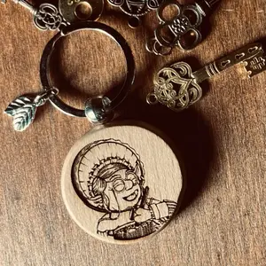 Granny’s Health Charm Keychain. Wood engraved with a portrait of Granny Goblin brewing up a stew just for you! Completed with 2 leaves from her herb cabinet.