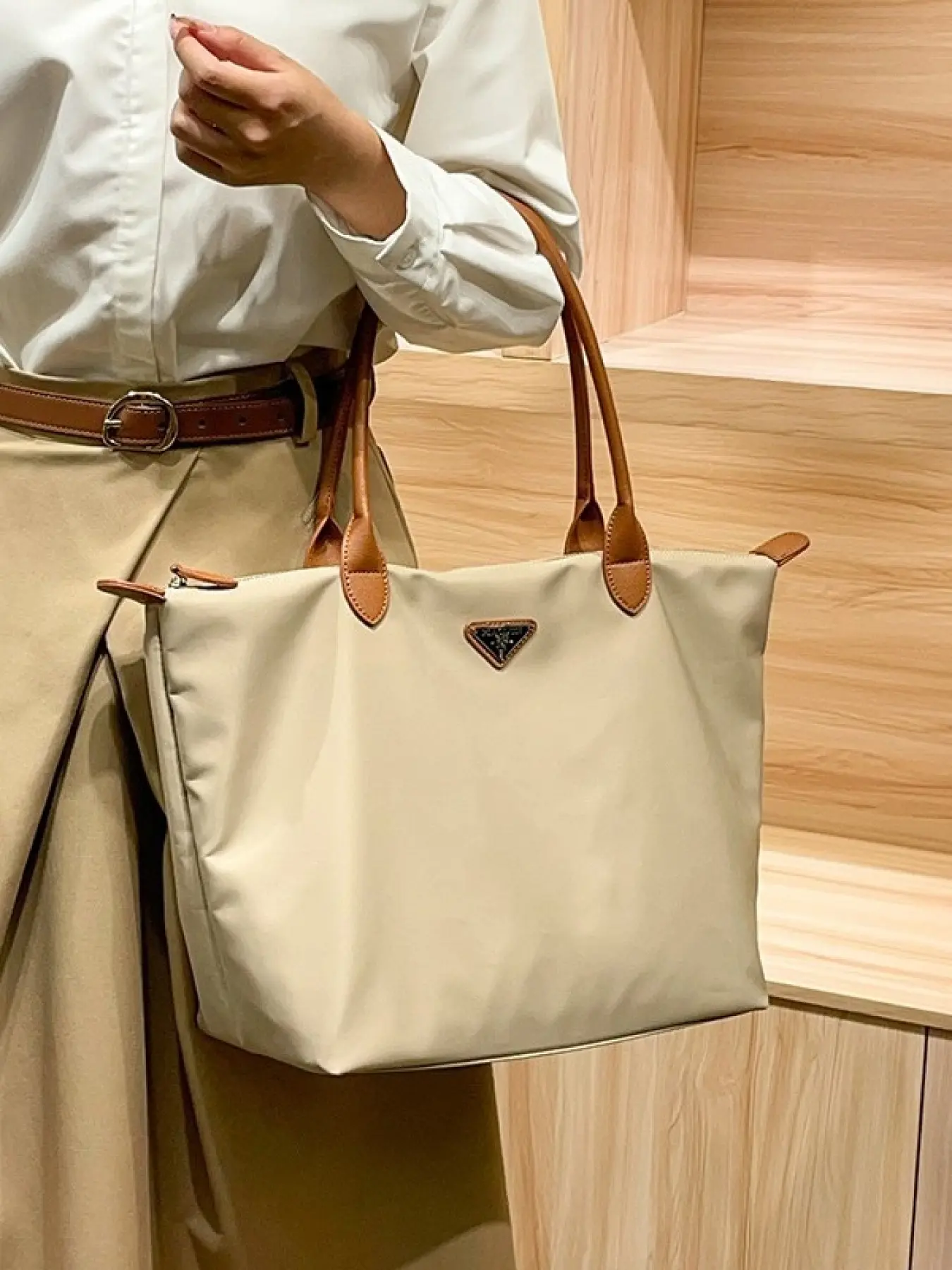 The commuter bag is made of imported nylon fabric paired with genuine leather, a new large-capacity handbag, and a lightweight, simple shoulder bag.