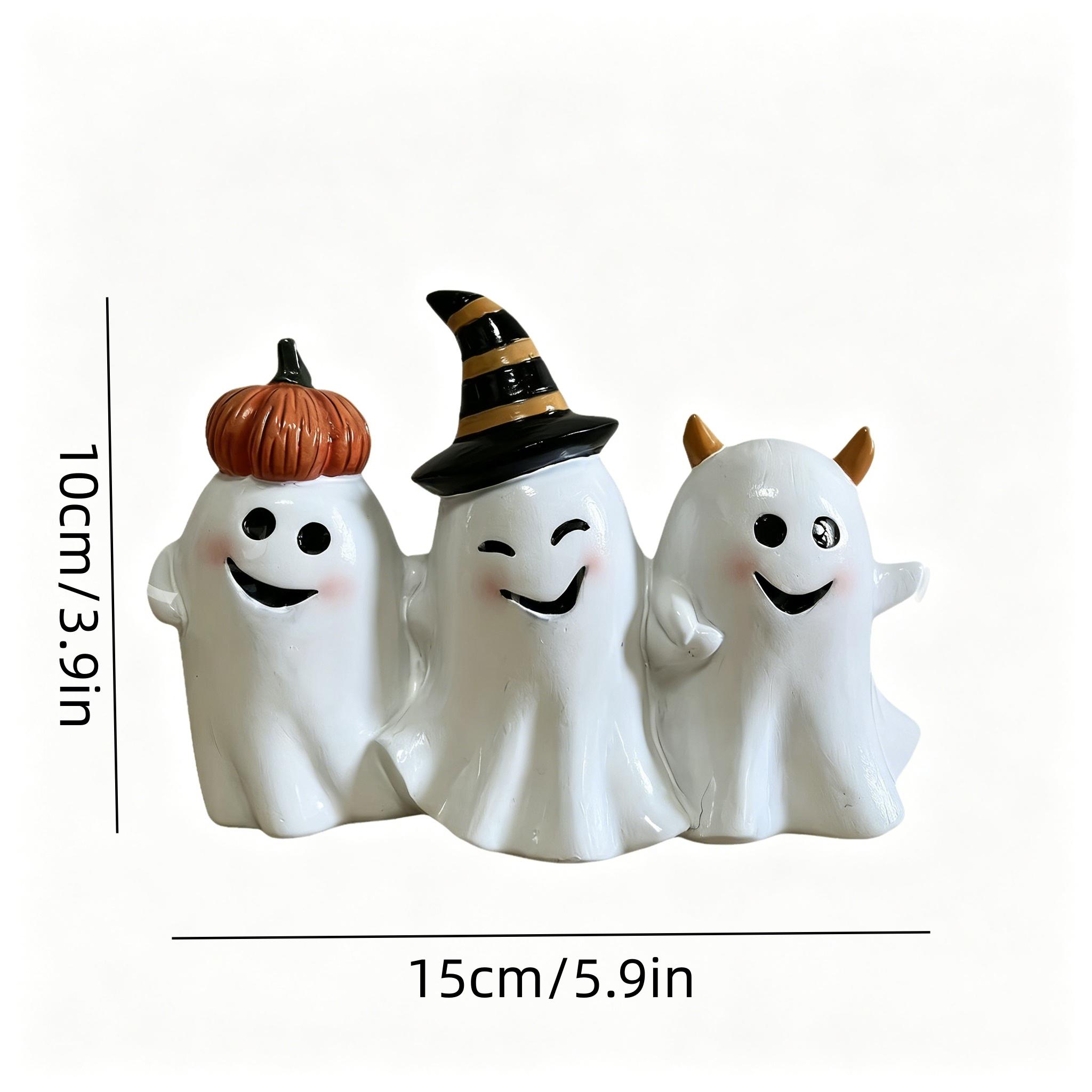 The whimsical trio of Smiling Ghosts - a group of people with crazy smiles - are decorating pumpkins as witches and devils for Halloween.